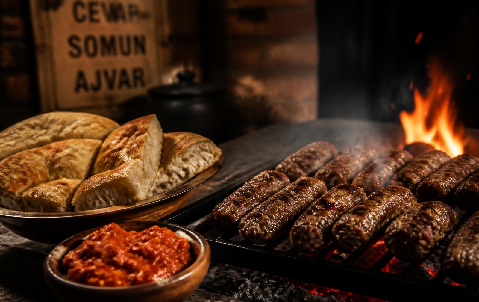 Qebapa duke u pjekur mbi thëngjill me somun dhe ajvar